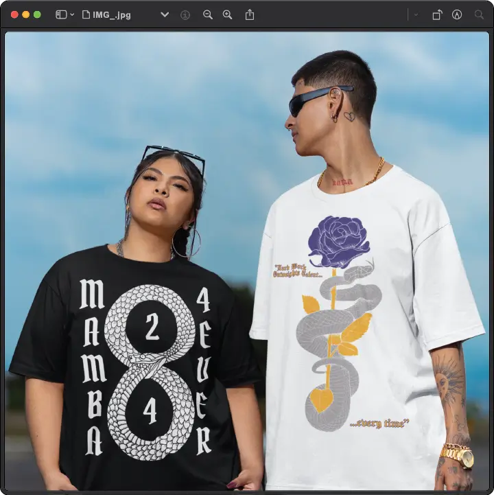 Two people in graphic T-shirts stand outside. The woman wears a black Mamba 24 Ever shirt; the man wears a white shirt with a rose and snake design. Both wear sunglasses.