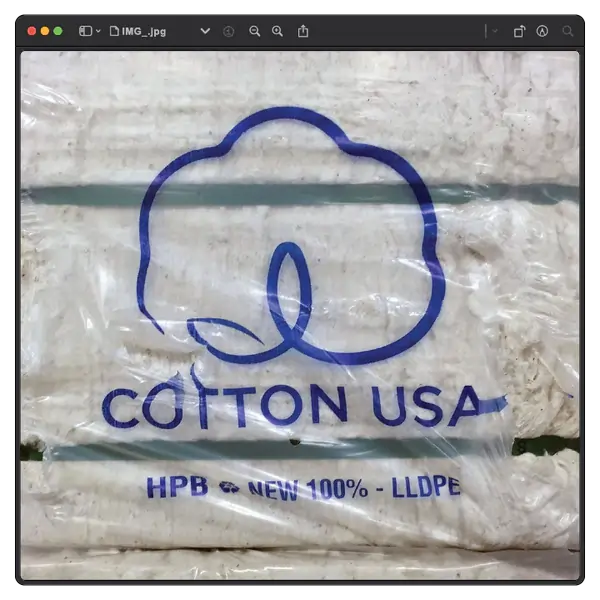 Plastic packaging with a blue logo of a cotton symbol and the text Cotton USA along with HPB and New 100% LLDPE. Inside is a compressed bale of cotton fibers.