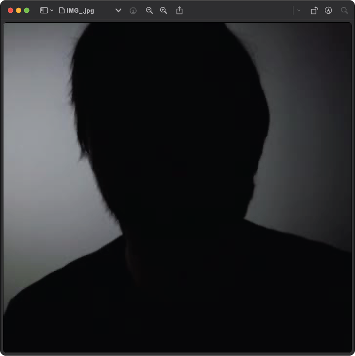 A persons face in the dark.